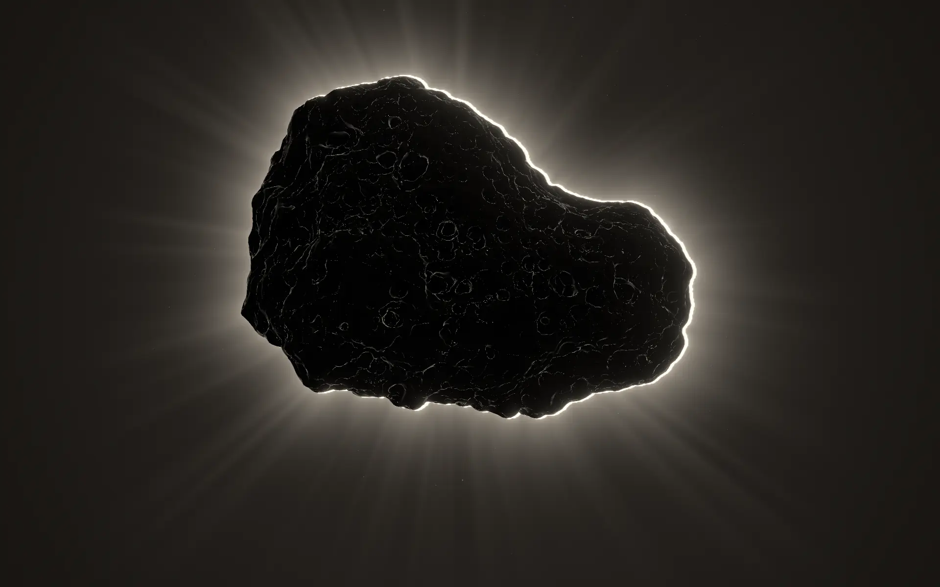 The pumice, dark against a ring of light behind it, on the studio’s charcoal.