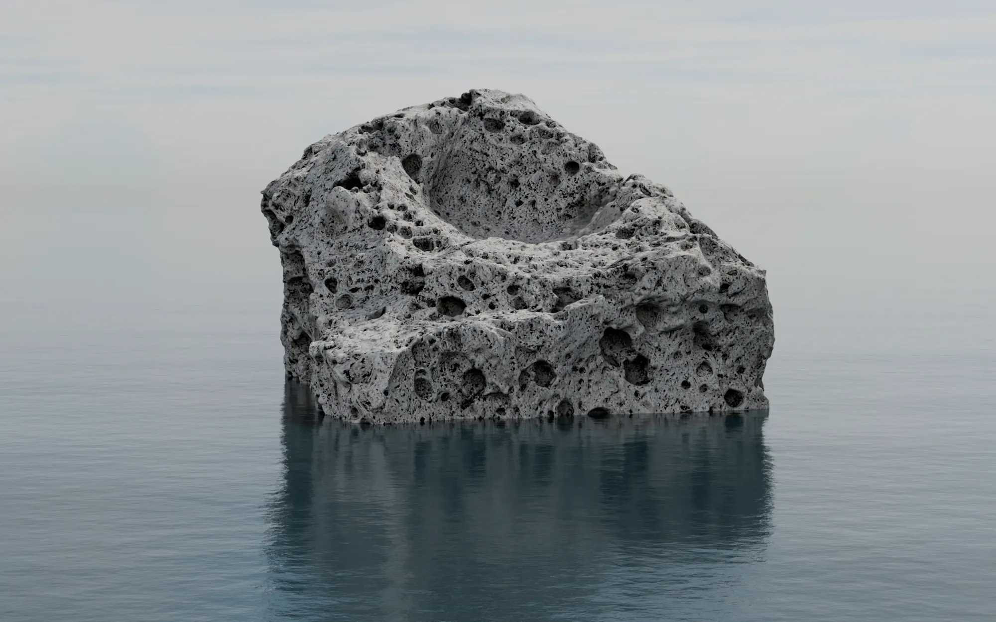 A block of pumice floating alone on a flat grey sea, its reflection beneath it.