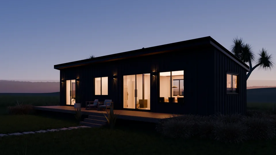 The same house at dusk, every room lit warm behind the glass, wall lights washing the black cladding.